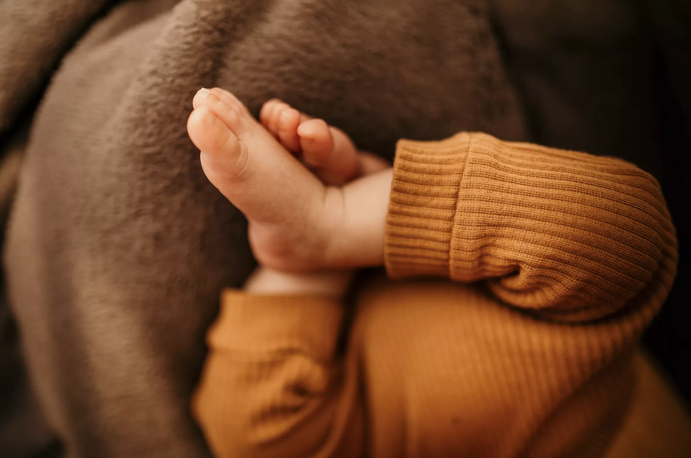 Ніжки немовляти до одного року на ковдрі, крупним планом